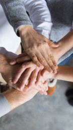 Group of team members holding hands at the office